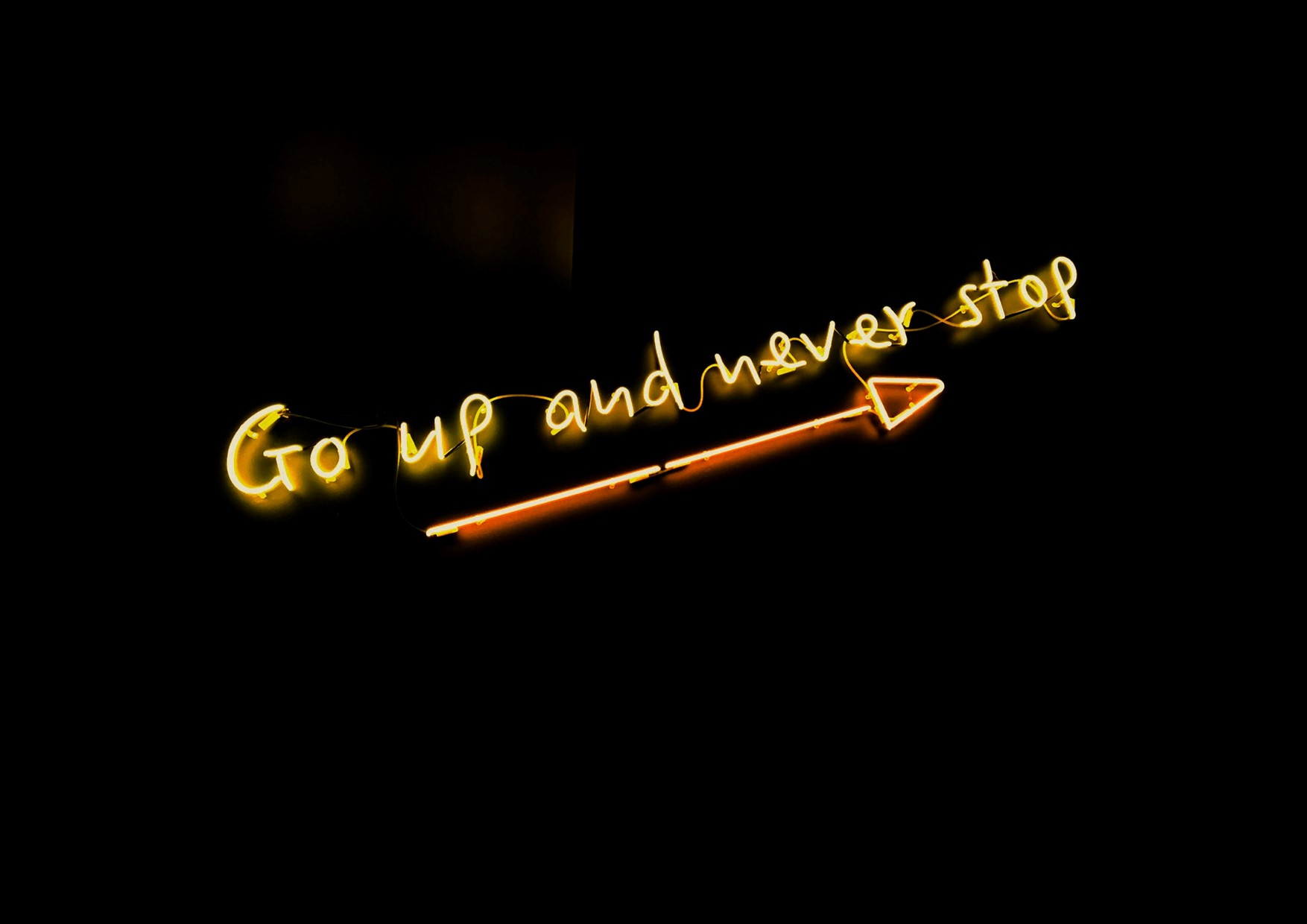 A neon sign saying 'Go up and never stop'