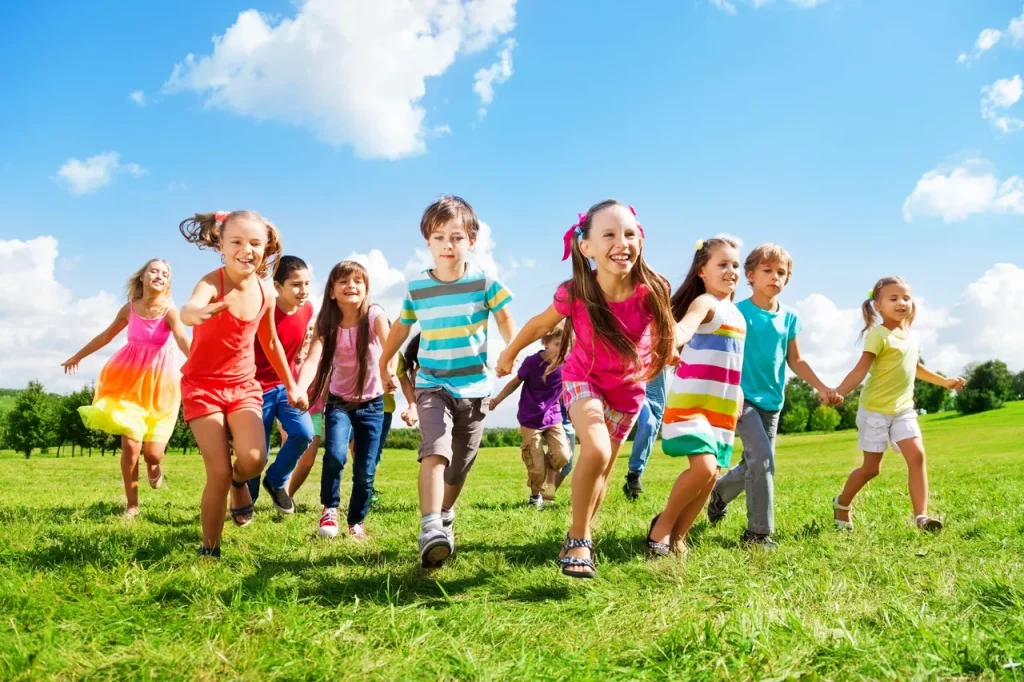 A group of smiling children running across a field