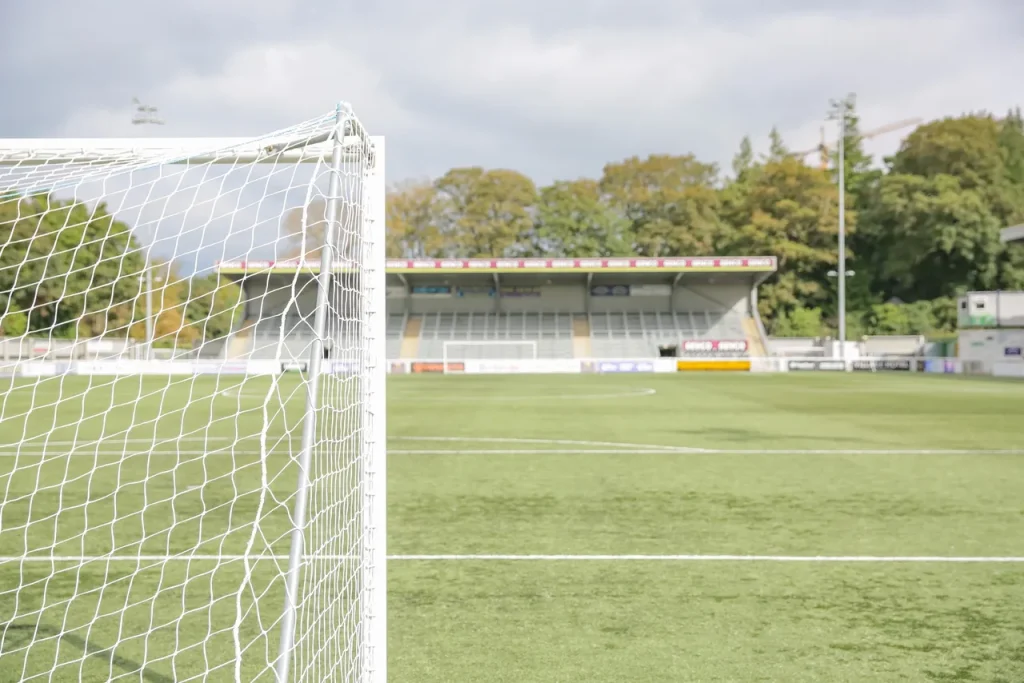 A behind the goal view of a football pitch on a sunny day