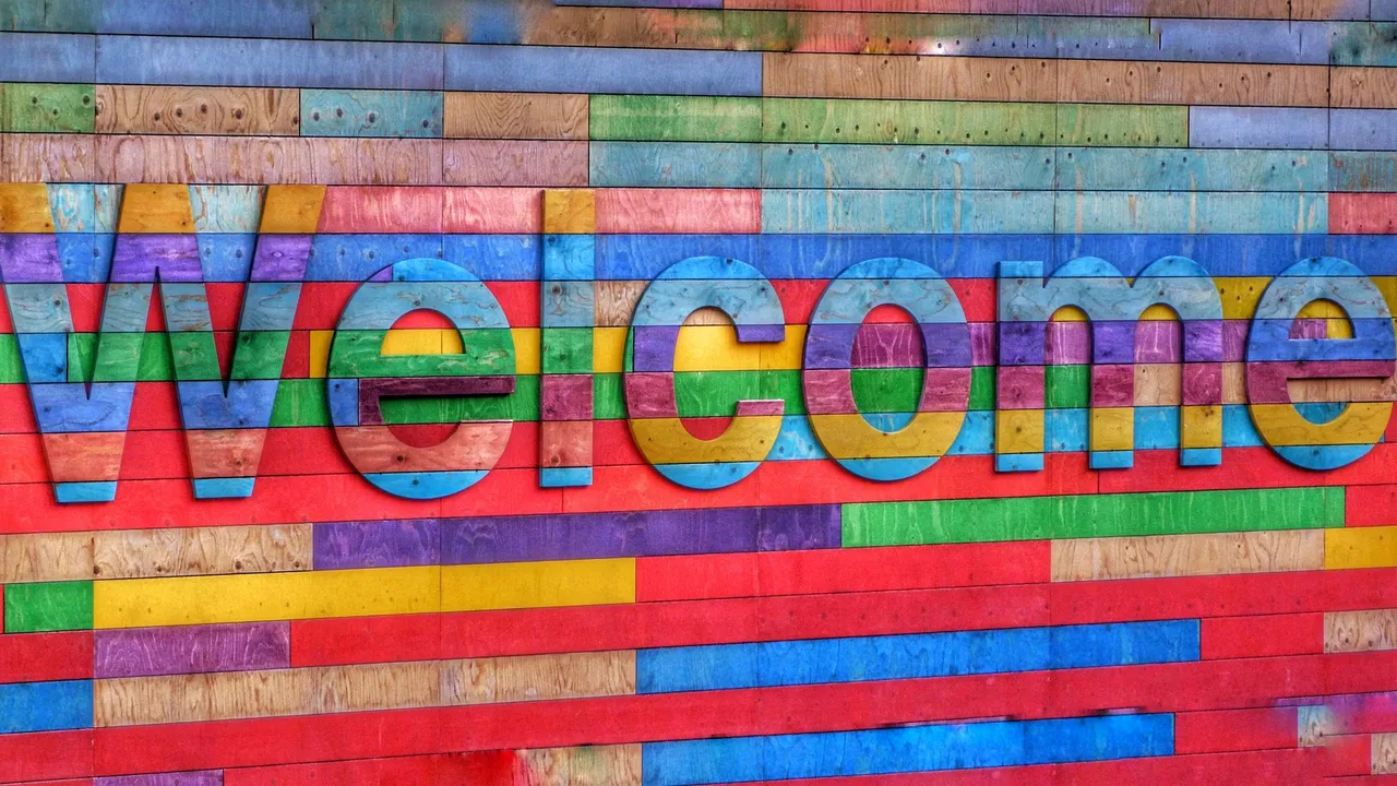 A multicoloured wall with the word 'Welcome' on it