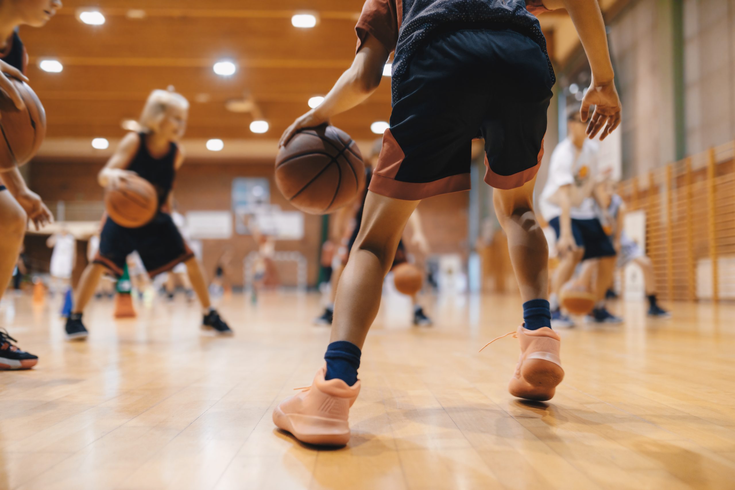 A group of girls playing basketball indoors