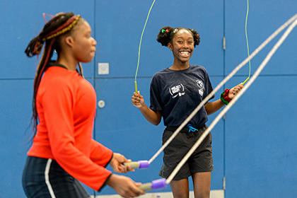 2 teenage girls smiling and skipping